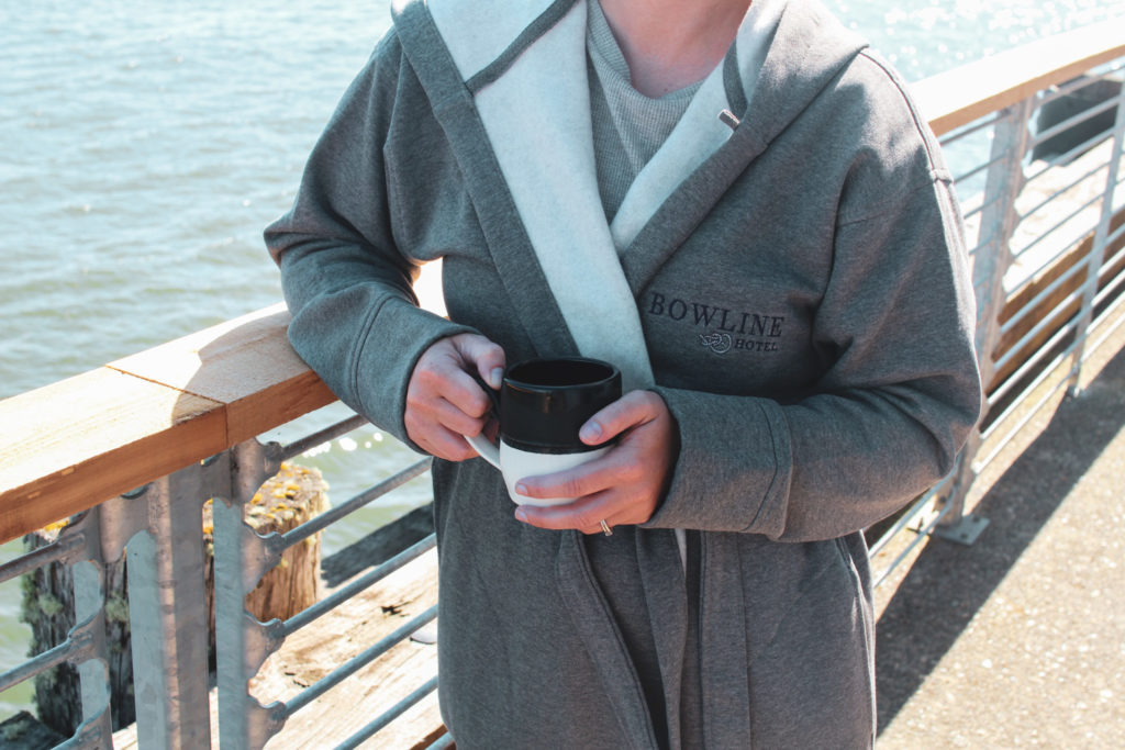 man holding coffee in bathrobe by columbia river