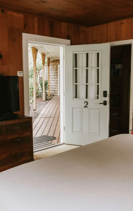 Cosy wooden hotel room with TV, fireplace, and patio view, offering a relaxing retreat for guests.