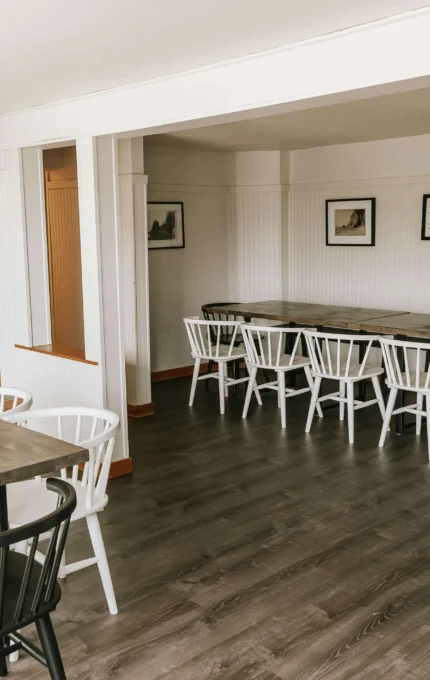 Spacious hotel lounge with modern wooden tables, cosy chairs, and fireplace—perfect for relaxation and group gatherings.