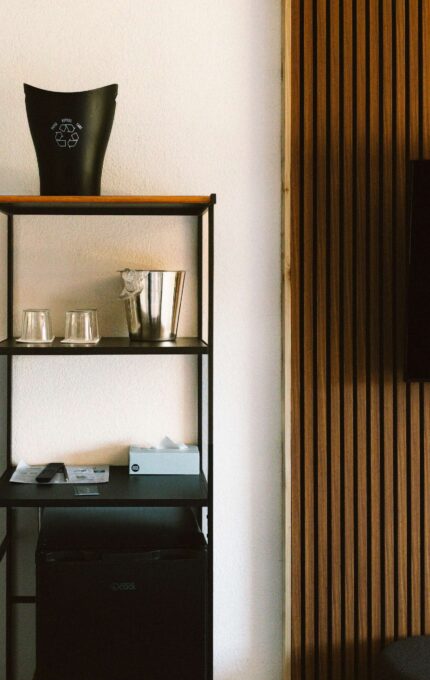 Guest room details at the Adrift Hotel in Long Beach, Washington — wall-mounted TV on a wood slat wall, mini fridge, and in-room recycling bin