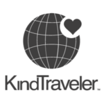 The image features the logo of "KindTraveler." It includes a stylized globe with grid lines and a heart shape partially overlapping the upper right region of the globe. The text "KindTraveler" is written below the globe in a clean, modern font.