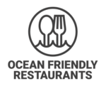 Logo of Ocean Friendly Restaurants, featuring a circular design with an illustration of a spoon and a fork above wavy lines representing the ocean. The text "Ocean Friendly Restaurants" is written below the circle in bold letters.