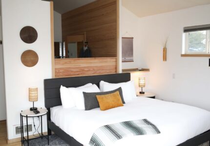 King bed against a reclaimed wood accent wall in a Luxe King room at the Inn at Manzanita, Oregon.