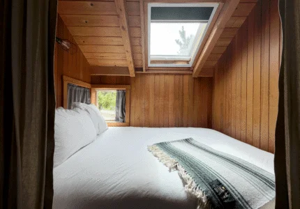 Cosy Captain King bedroom with skylight and plush bed, showcasing serene nature views and tranquil retreat vibes.