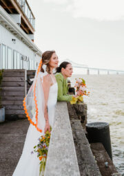 Guests enjoying sea views from hotel terrace with flowers, highlighting seaside relaxation and scenic waterfront experience.