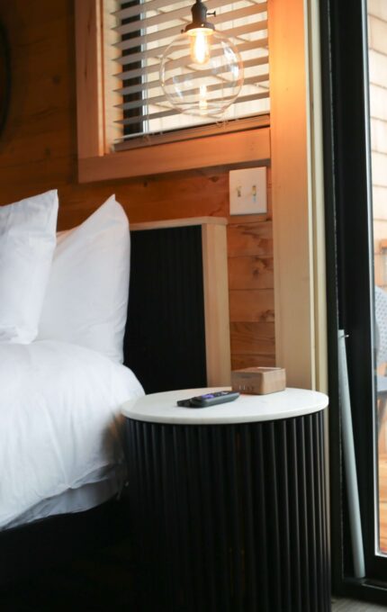 Cosy hotel room with plush bed and balcony, offering scenic views and inviting warmth for a relaxing stay.