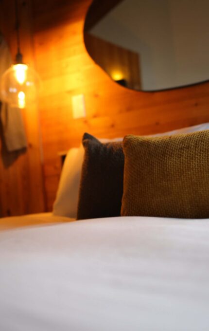 Cosy hotel room with elegant lighting, soft pillows, and modern decor for a relaxing stay.