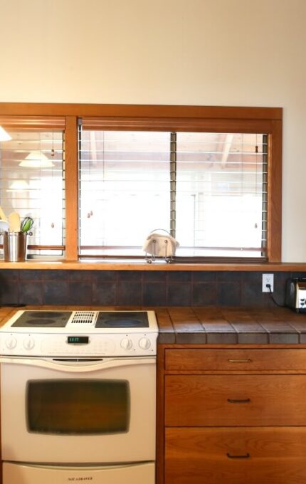 Cosy hotel kitchen with modern appliances and wooden cabinets offering a homely experience for guests.