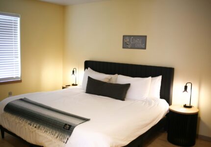 Spacious hotel room with king-size bed, modern lighting, cosy décor, and soft linens offering a relaxing stay.
