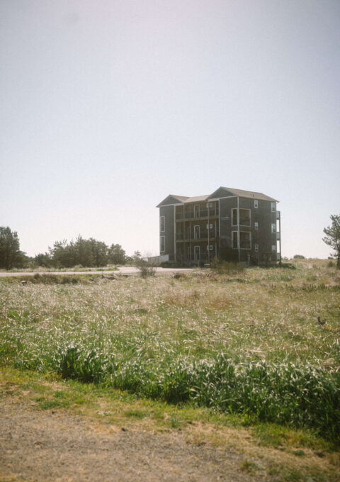Quaint countryside hotel surrounded by lush green fields under a clear sky, offering a serene retreat.