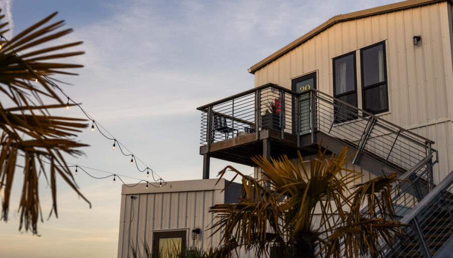 Private balcony and string lights at sunset at the Bowline Hotel, a waterfront boutique hotel in Astoria, Oregon.